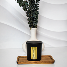 Load image into Gallery viewer, Stylish Linen Daze candle in a black matte jar with gold foil label, paired with a modern white vase and peach-toned dried florals for a clean aesthetic.