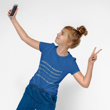Load image into Gallery viewer, Person wearing a blue t-shirt with 'Peace is my priority' text, taking a selfie on a white background
