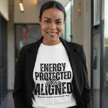 Load image into Gallery viewer, Woman wearing a white t-shirt with text 'ENERGY PROTECTED VIBE ALIGNED' in an indoor setting.
