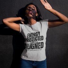 Load image into Gallery viewer, Woman wearing a t-shirt with text 'ENERGY PROTECTED Vibe ALIGNED' against a dark background
