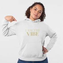 Load image into Gallery viewer, Person wearing a white hoodie with 'I AM THE VIBE' text on a plain background
