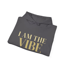 Load image into Gallery viewer, Folded gray hoodie with 'I AM THE VIBE' text in gold on a white background
