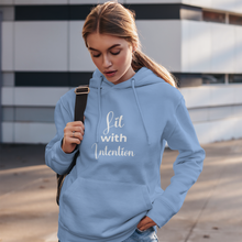Load image into Gallery viewer, Woman wearing a light blue hoodie with 'Lit with Intention' text, standing outdoors.
