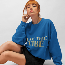 Load image into Gallery viewer, Woman wearing a blue sweatshirt with 'I AM THE VIBE' text on a plain background
