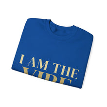 Load image into Gallery viewer, Folded blue t-shirt with 'I AM THE VIBE' text in gold on a white background
