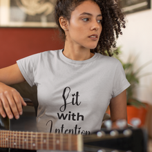 Load image into Gallery viewer, Woman wearing a t-shirt with 'Lit with Intention' text, holding a guitar.
