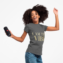 Load image into Gallery viewer, Woman wearing a gray t-shirt with 'I AM THE VIBE' text, holding a black speaker.
