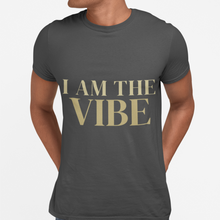 Load image into Gallery viewer, Person wearing a dark gray t-shirt with 'I AM THE VIBE' text in gold on a light gray background
