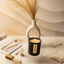 Load image into Gallery viewer, Candle with a decorative vase and other items on a light surface
