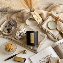 Load image into Gallery viewer, Candle with decorative items on a textured surface
